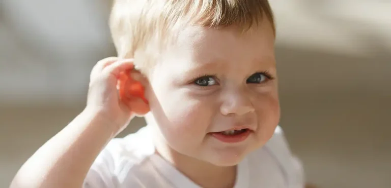 Fotografía de niño tocándose la oreja. Un síntoma de otitis.