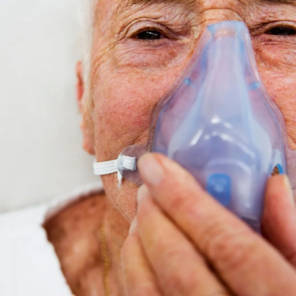 Fotografía en primer plano de un paciente con mascarilla en un tratamiento de rehabilitación pulmonar para EPOC