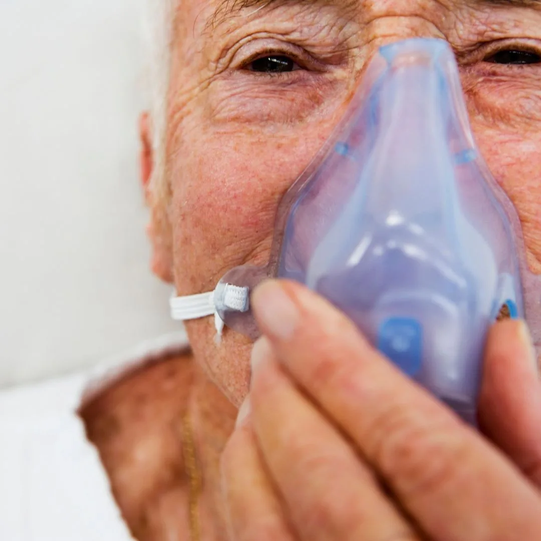 Fotografía en primer plano de un paciente con mascarilla en un tratamiento de rehabilitación pulmonar para EPOC