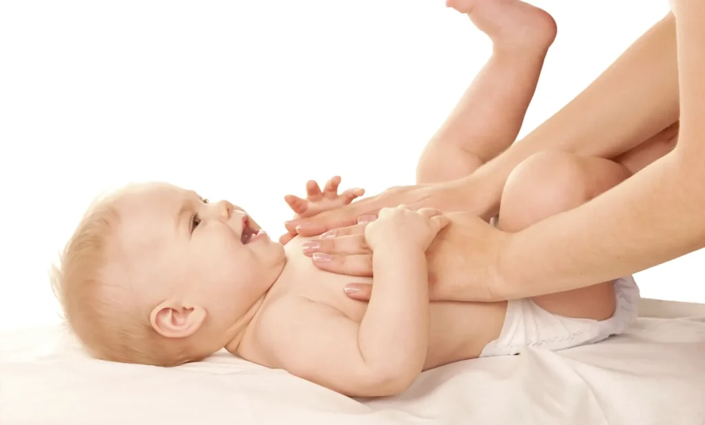 Fotografía de bebe con bronquitis siendo masajeado en el pecho por su madre, con VapoRub