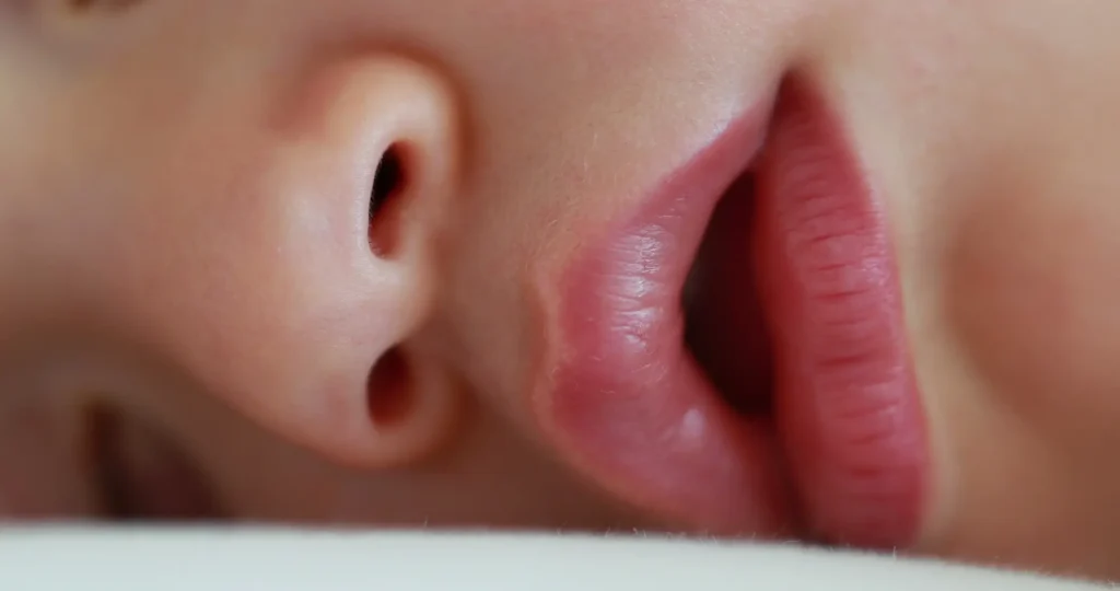 Imagen de detalle de la cara de un niño durmiendo, respirando con la boca abierta.