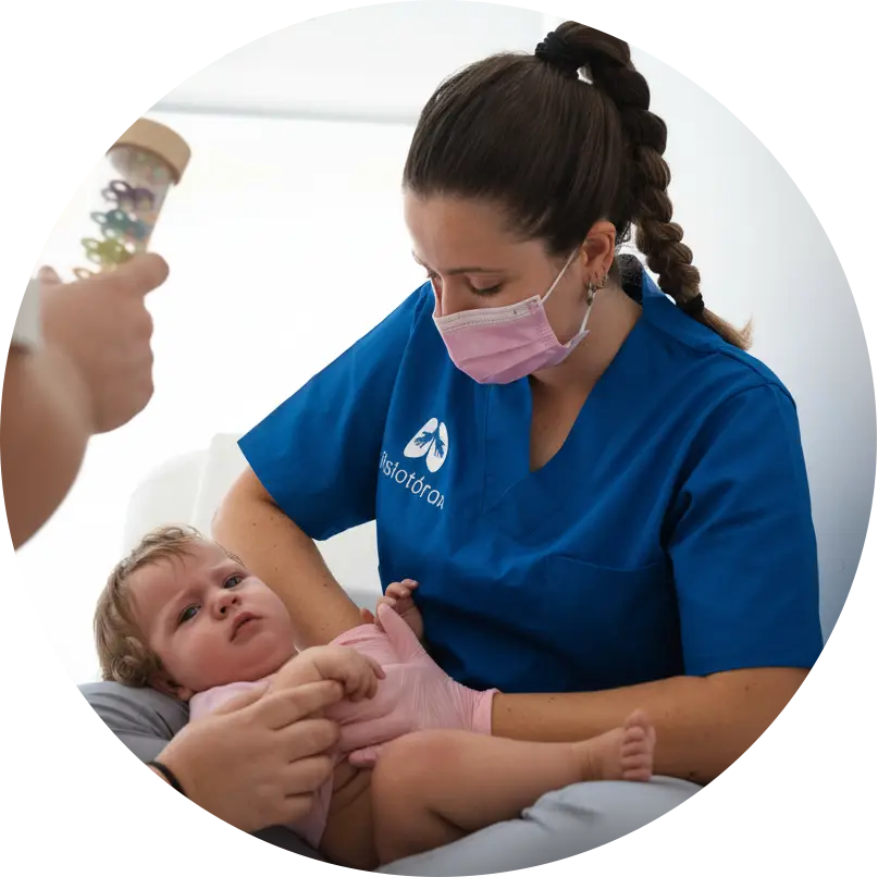 Fotografía de una fisioterapeuta respiratoria tratando a un bebe