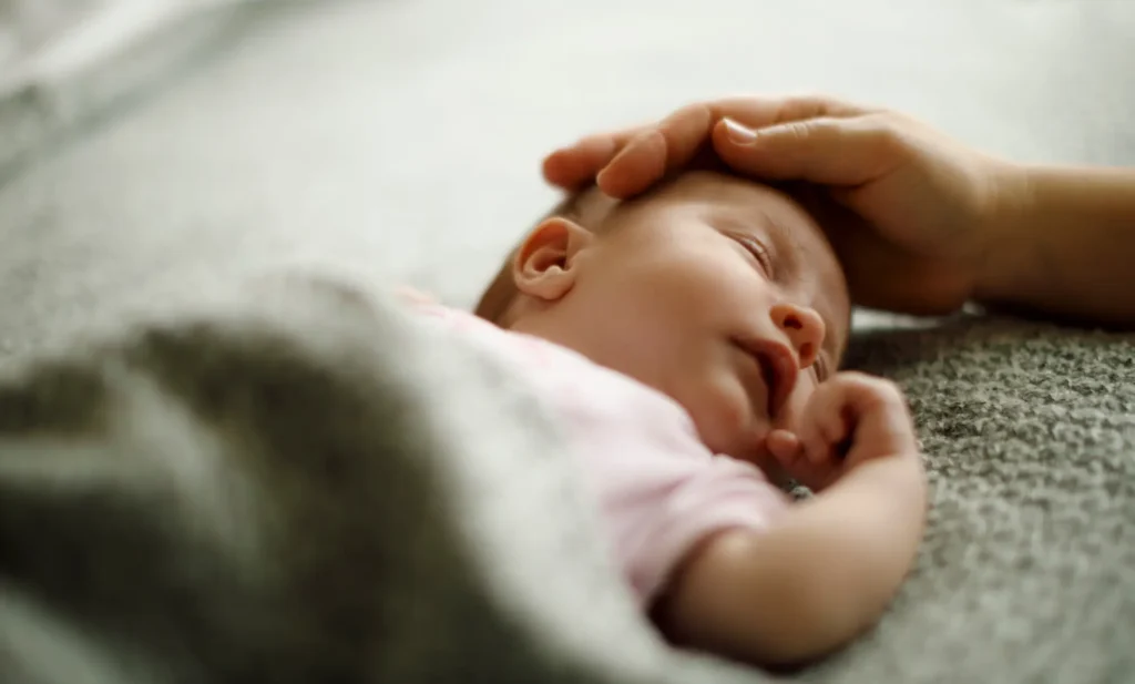 Fotografía de un bebe con bronquilitis recibiendo cuidados de su madre