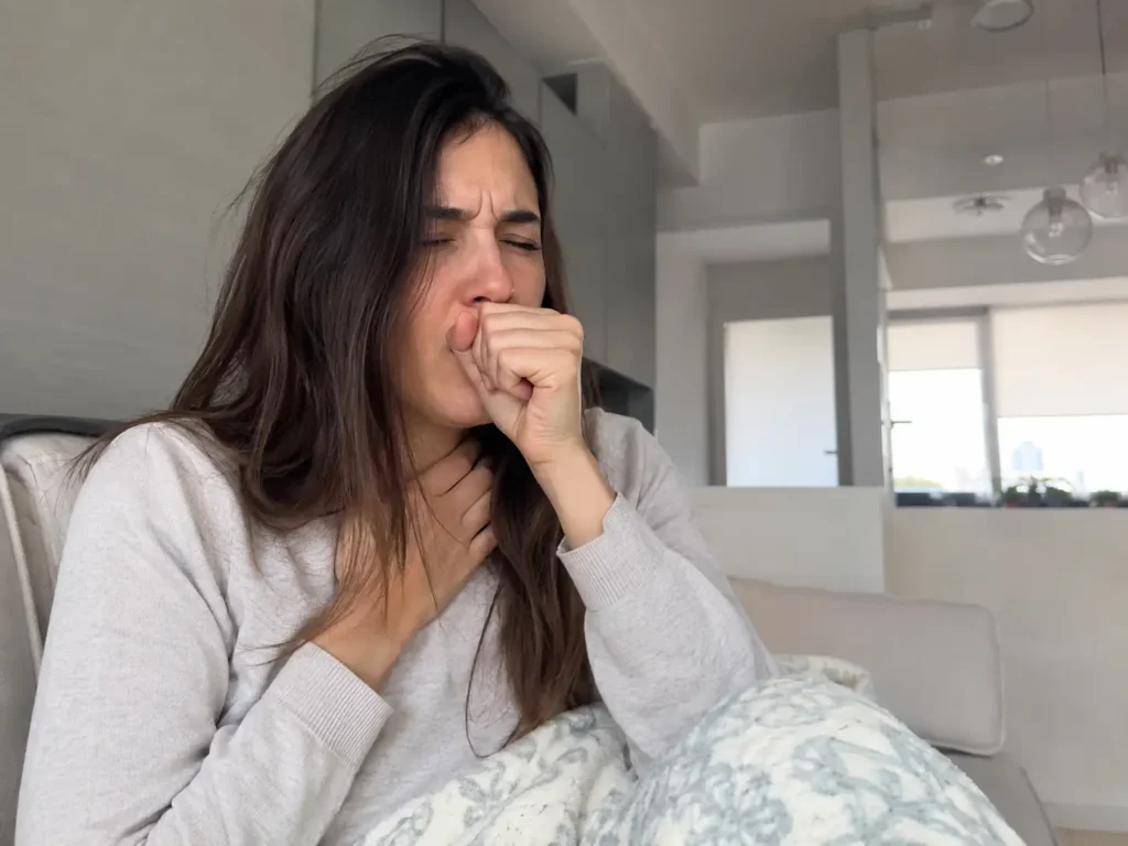 Fotografía de chica tosiendo a causa de una neumonia