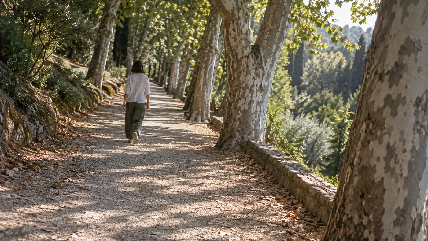 Persona paseando por un sendero arbolado como parte de su actividad física diaria
